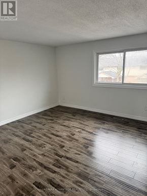 London East (East I) townhouse for rent - A room with a window and a wooden floor.