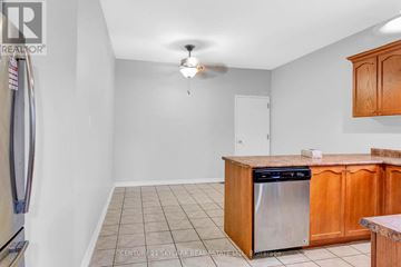Bradford West Gwillimbury (Bradford) apartment for rent - A kitchen with wooden cabinets and a tile floor.