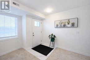 Asphodel-Norwood (Norwood) townhouse for rent - A room with a white door, a plant on a green stand, and a framed picture on the wall.