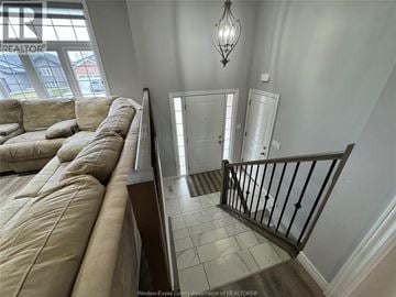 Windsor apartment for rent - A living room with a beige couch and a chandelier.