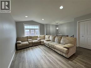 Windsor apartment for rent - A living room with a large sectional sofa and a window.