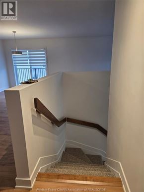 Clarence-Rockland apartment for rent - A staircase with a wooden handrail and a carpeted runner.