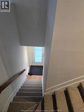 Clarence-Rockland apartment for rent - A stairway with a carpeted runner and a wooden handrail.