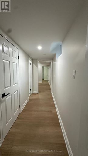 Toronto (Weston) apartment for rent - A long hallway with white doors and wooden floors.