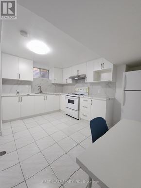 Toronto (Agincourt North) apartment for rent - A white kitchen with a marble counter top and a single blue chair.