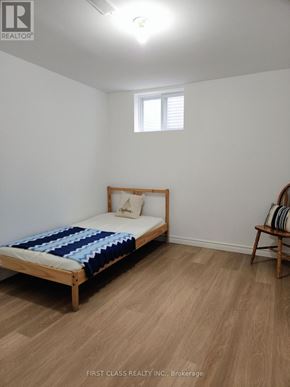 Toronto (Agincourt North) apartment for rent - A bedroom with a bed, a chair, and a window.