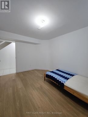 Toronto (Agincourt North) apartment for rent - A bedroom with a bed and wooden floors.