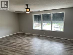 Tecumseh apartment for rent - A room with a large window and wooden flooring.