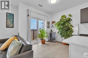Windsor condo for rent - A living room with a grey couch and a painting on the wall.