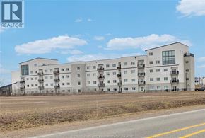 Windsor condo for rent - A large white apartment building with a REALTOR® logo in the corner.