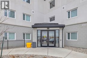 Windsor condo for rent - The front of a building with a black fence and a yellow trash can.