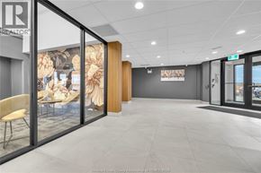 Windsor condo for rent - A modern office space with a glass wall and a wooden door.