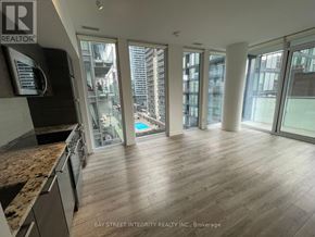 Toronto (Church-Yonge Corridor) condo for rent - A spacious room with wooden flooring and large windows overlooking a cityscape.