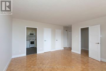Toronto (Mount Pleasant East) condo for rent - A white room with a kitchen in the background and a doorway leading to another room.