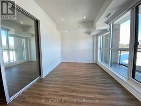 Toronto (West Hill) condo for rent - A spacious room with wooden flooring and large windows.