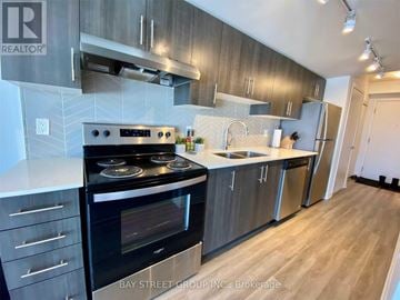 Toronto (West Hill) condo for rent - A modern kitchen with a stove top oven and a refrigerator.