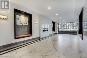 Toronto (Steeles) condo for rent - A hallway with marble floors and a painting on the wall.