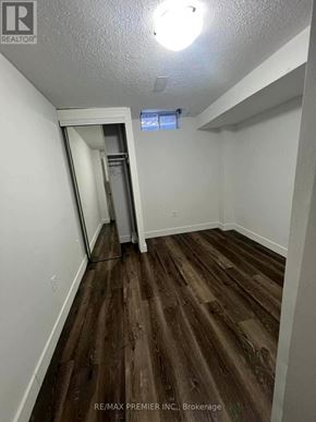 Vaughan (Maple) apartment for rent - A room with wood flooring and a white wall with a doorway leading to another room.