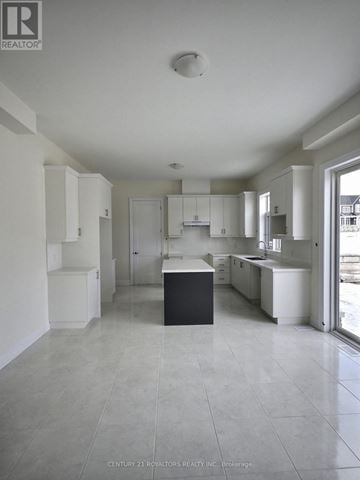 Oro-Medonte apartment for rent - A spacious kitchen with white cabinets and a black island.