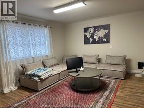 Windsor apartment for rent - A living room with a couch, a coffee table, and a television.