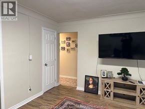 Windsor apartment for rent - A living room with a flat screen TV mounted on the wall and a wooden entertainment center.