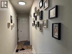 Windsor apartment for rent - A hallway with a white door and pictures on the wall.