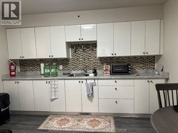 Windsor apartment for rent - A kitchen with white cabinets and a patterned backsplash.