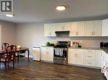 Windsor apartment for rent - A kitchen with white cabinets and a wooden table.