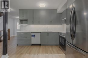 Toronto (Kensington-Chinatown) apartment for rent - A modern kitchen with stainless steel appliances and grey cabinets.