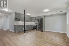 Toronto (Kensington-Chinatown) apartment for rent - A spacious kitchen with wooden floors and grey cabinets.