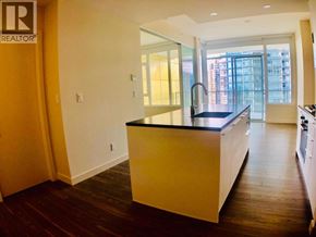 Burnaby apartment for rent - A kitchen with a black countertop and wooden floors.