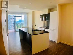 Burnaby apartment for rent - A modern kitchen with a black countertop and white appliances.
