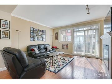 Surrey townhouse for rent - A living room with a black leather couch and a checkered rug.