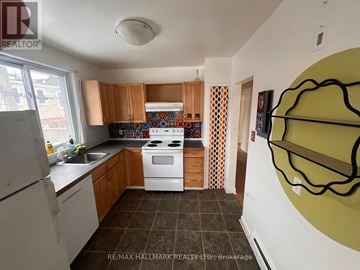 Toronto (Woodbine Corridor) triplex for rent - A kitchen with a white stove top oven and white refrigerator.