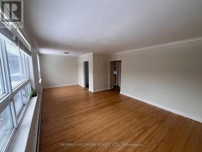Toronto (Woodbine Corridor) triplex for rent - A room with wooden flooring and white walls, with a window on the left side.