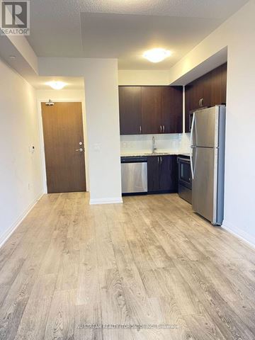 Markham (Wismer) condo for rent - A kitchen with a refrigerator, sink, and cabinets.