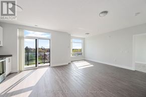 Tillsonburg multi-family for rent - A spacious room with wooden flooring and a large window overlooking a balcony.