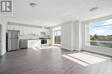 Aylmer multi-family for rent - A spacious kitchen with white cabinets and a refrigerator.