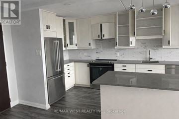 Toronto (Dorset Park) condo for rent - A kitchen with white cabinets and a black dishwasher.
