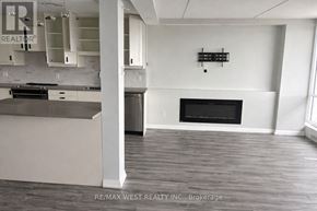 Toronto (Dorset Park) condo for rent - A large, empty room with a fireplace and a kitchen area.