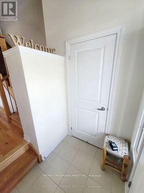 Pickering apartment for rent - A white door is in a hallway with a wooden staircase on the left.