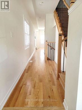Pickering apartment for rent - A long hallway with wood floors and a staircase on the right.