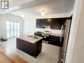 Pickering apartment for rent - A kitchen with a refrigerator on the right side.