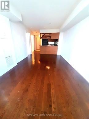 Mississauga (City Centre) condo for rent - A long hallway with wood floors and white walls.