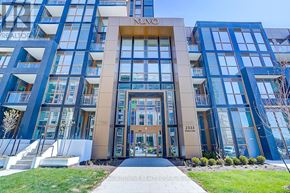 Oakville (Wm Westmount) condo for rent - A modern building with a glass facade and a central entrance.