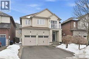 Ancaster apartment for rent - A two-story house with a garage is surrounded by a snowy landscape.