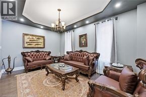 Ancaster apartment for rent - A living room with brown leather furniture and a chandelier.