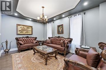 Ancaster apartment for rent - A living room with brown leather furniture and a chandelier.