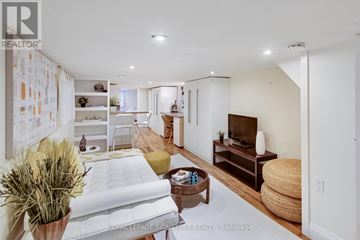 Toronto (Woodbine-Lumsden) apartment for rent - A well-lit, modern living room with a white sofa and a television.
