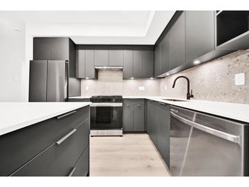 Langley apartment for rent - A modern kitchen with dark cabinets and stainless steel appliances.
